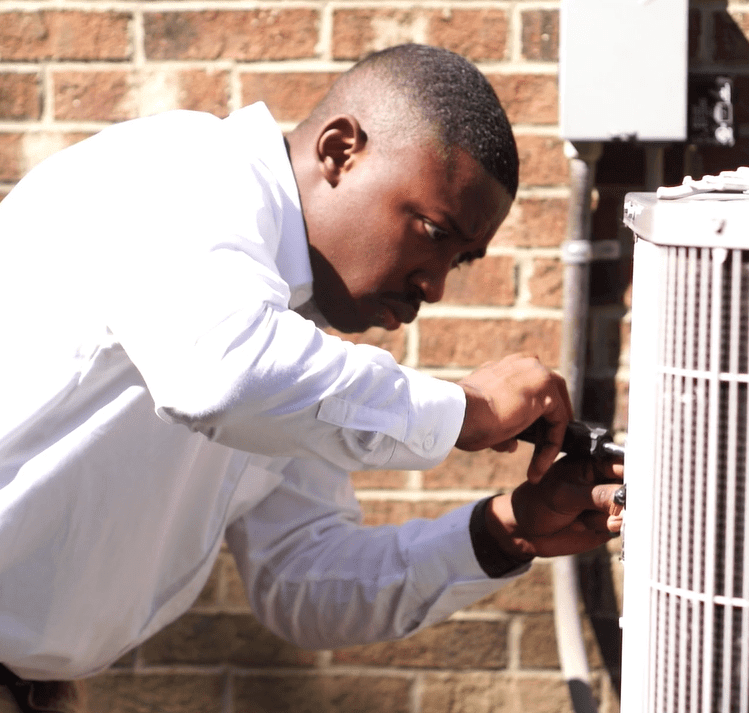 a technician inspecting an air conditioning unit Southfield MI
