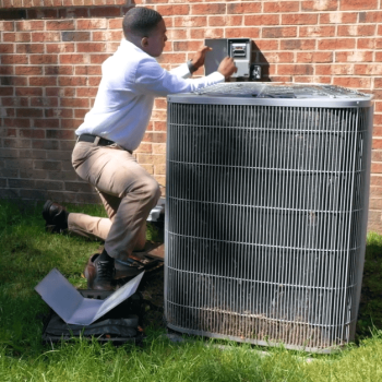 a technician inspecting an air conditioning unit Belleville MI