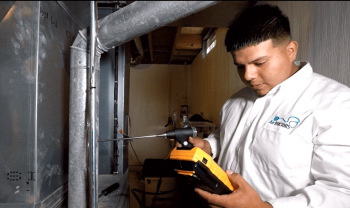 a technician inspecting a furnace Belleville MI