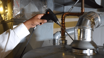 a technician inspecting a furnace Belleville MI