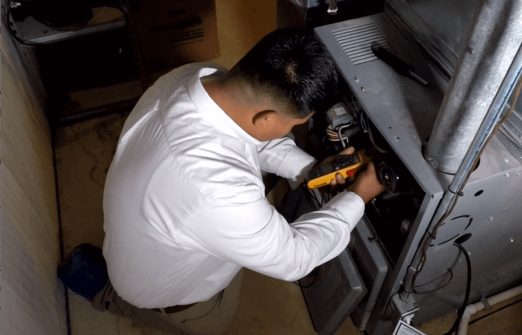 a technician inspecting a furnace Southfield MI