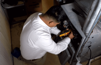 a technician inspecting a furnace Belleville MI