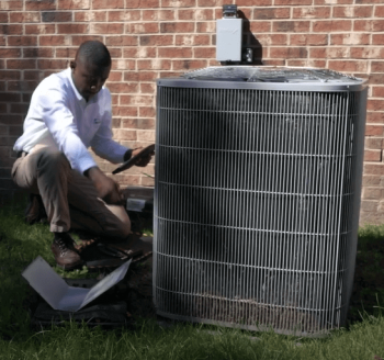 a technician inspecting an air conditioning unit Belleville MI